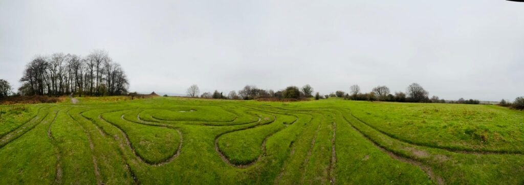 A panoramic photo of at the top of St Catherine's Hill in Winchester, and the Mizmaze, one of eight historic turf mazes still remaining in England