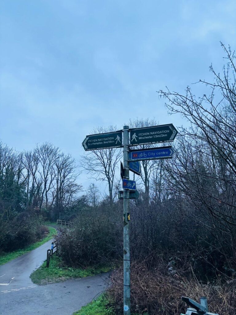 At a junction of footpaths and cycleways close to St Catherine's Hill in Winchester, stands a metal finger post sign with directions.