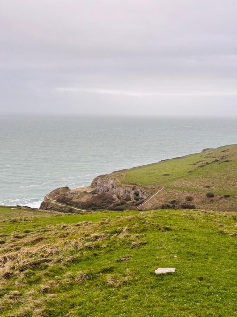 View from the higher path at Winspit Quarry looking down at the quarry and the lower South West Coast Path, Dorset