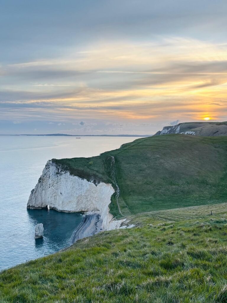 View west from Swyre Head across Bat’s Head with the sun setting over White Nothe on the Dorset Jurassic Coast