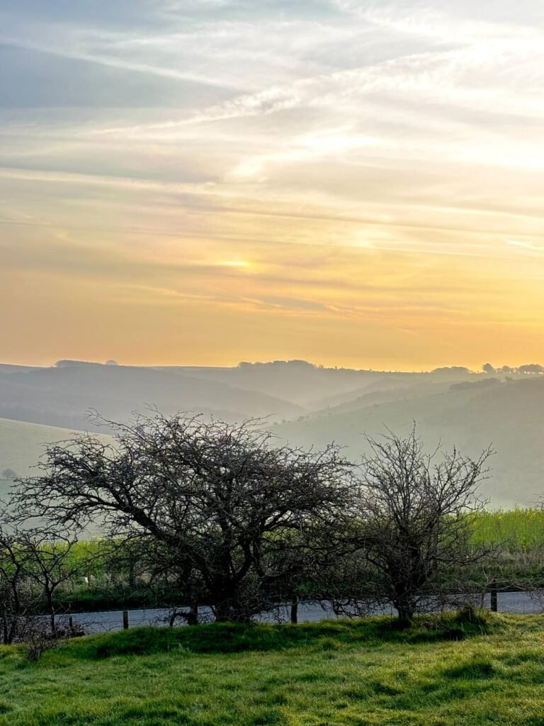 Sunrise mist covering Melbury Down viewed across Spread Eagle Hill