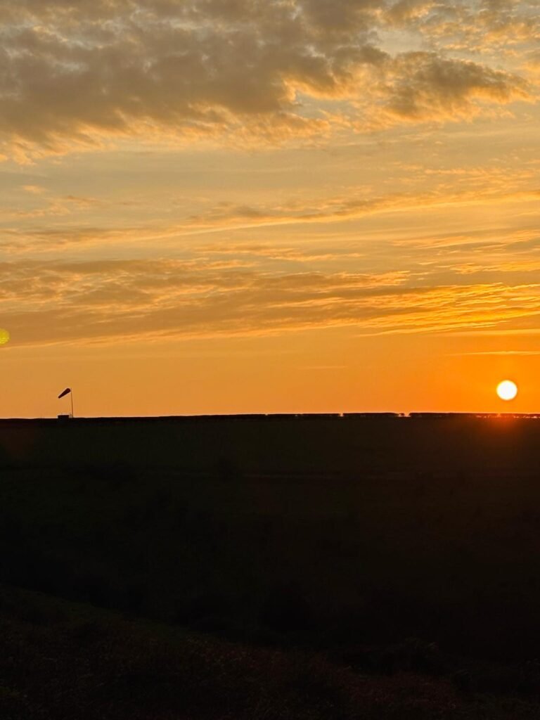 Sunset over Dorset hills with silhouetted windsock at Compton Abbas Airfield