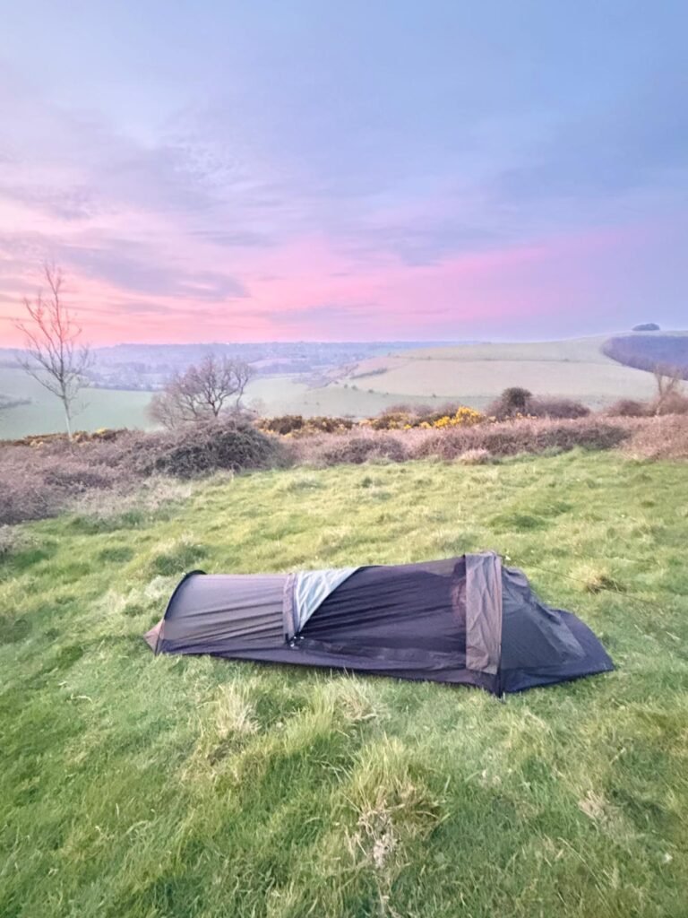 Nortent Skjul bivvi with bug mesh open on a Dorset hillside at dusk