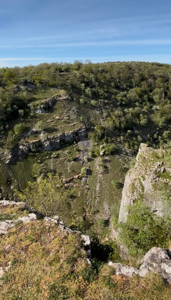 Looking across the steep rock faces and grassy slopes of Cheddar Gorge from the cliff top