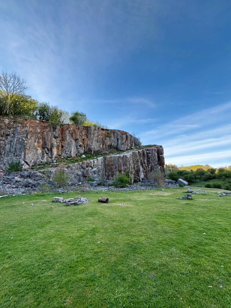 Black Rock Quarry with flat grass areas fire pits and tall quarry walls in Somerset