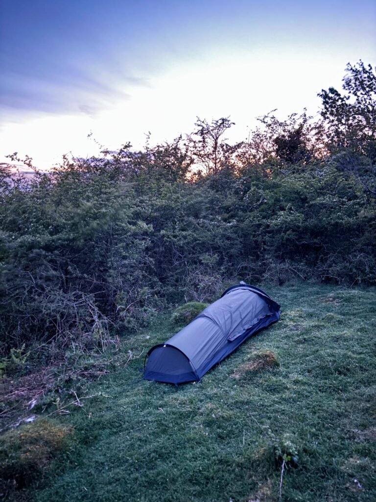 Nortent Skjul bivvi sheltering beside hawthorn bushes during a windy night above Cheddar Gorge