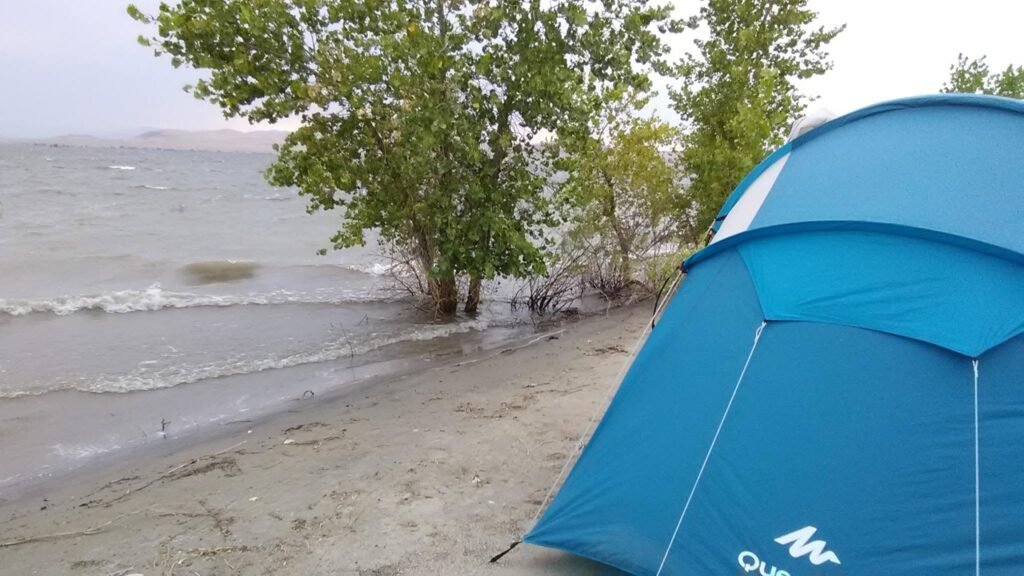 Tent pitched beside a reservoir in Arizona before strong evening winds rolled it down the beach.