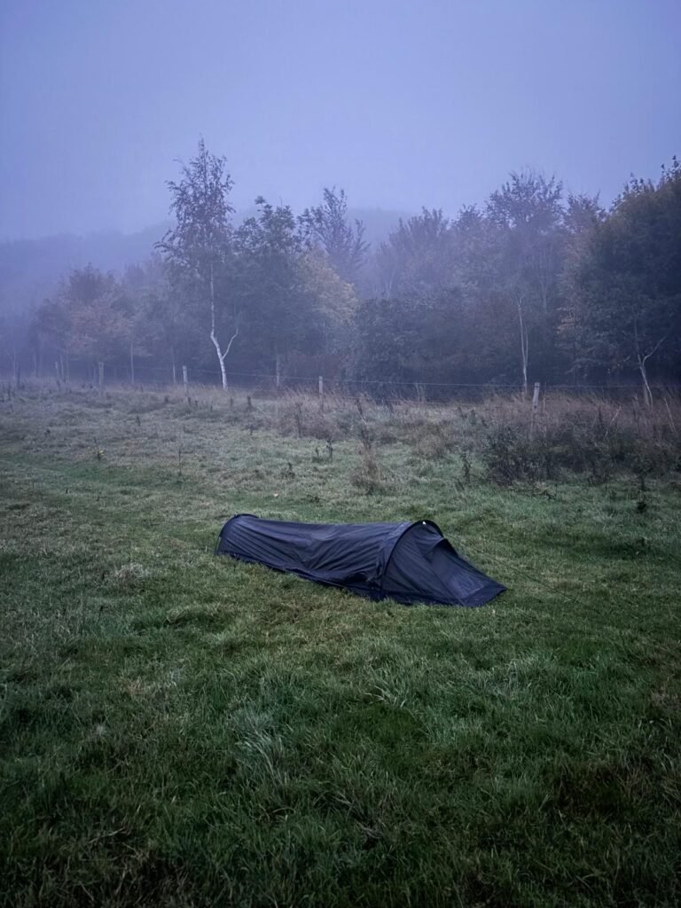 Nortent Skjul bivvi pitched on a misty hilltop beside woodland during a cold winter camp