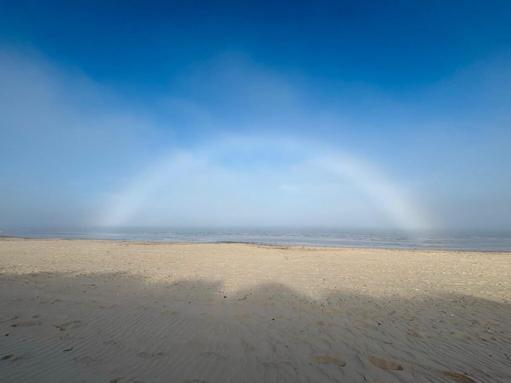 A fogbow visible above the sea beyond Studland Beach.