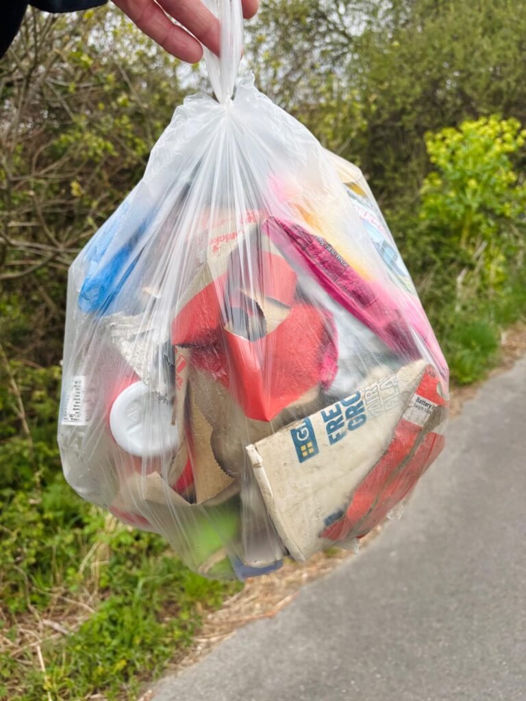 Holding a full bag of litter collected during a wild camping litter pick