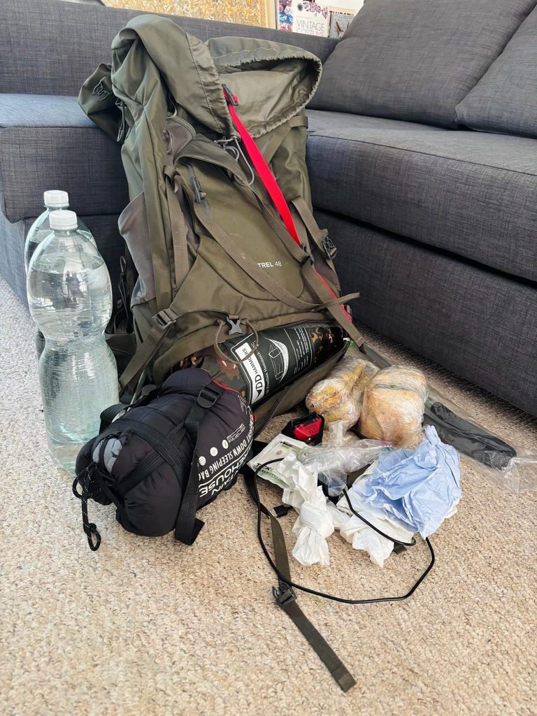 Wild camping equipment laid out ready to pack into an Osprey 48-litre backpack for a one-night trip outdoors.