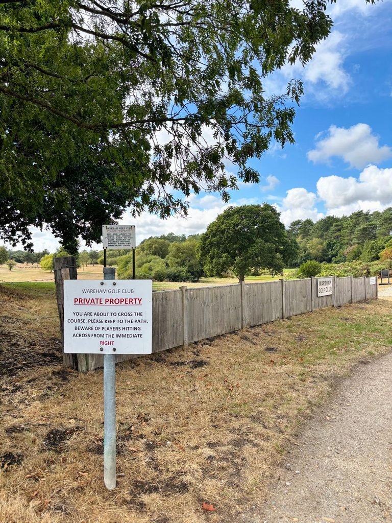 Warning sign beside the path crossing Wareham Golf Course