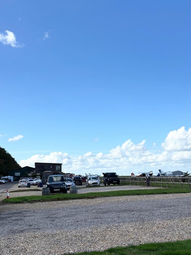 Light aircraft parked beside the grass runway at Compton Abbas Airfield